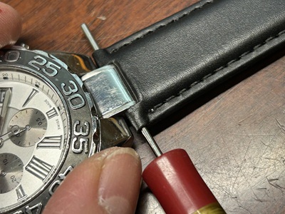 バネ棒工具で革ベルトを取り付ける写真