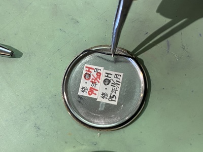 裏蓋内側のパッキンを点検している様子