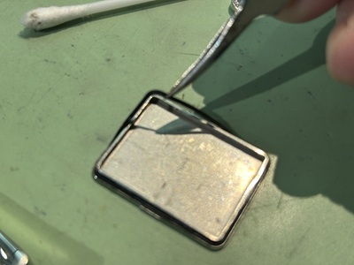 裏蓋のパッキンをピンセットで外している作業