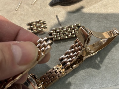 外したコマを手に持ち、調整量を確認している様子