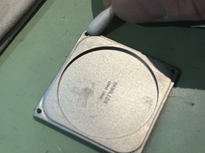 裏蓋の密閉面を綿棒で清掃している様子