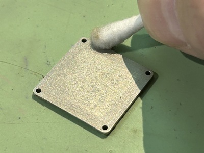 裏蓋プレートを綿棒で清掃している様子