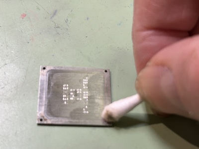 綿棒で裏蓋の裏側を掃除する様子