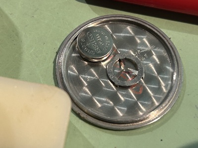 取り外した裏蓋とボタン電池（取り外し後の状態）