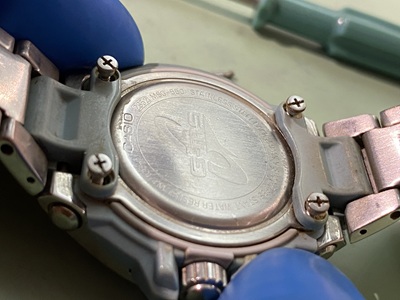 精密ドライバーで裏蓋の4点のネジを対角線上に緩めている作業