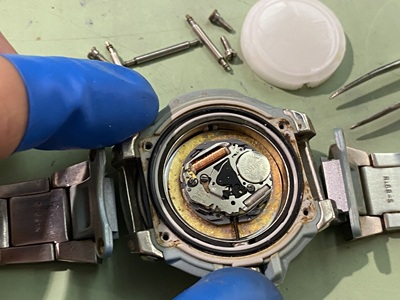 内部の白いカバーを取り外し、ムーブメントと古い電池が露出した状態