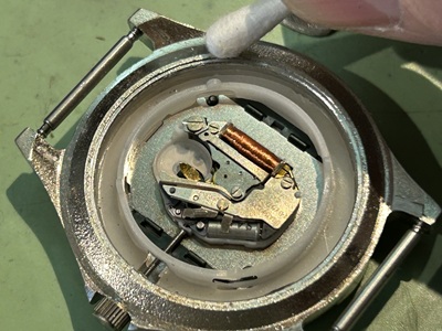 電池を取り出し、ケース縁の汚れを綿棒で清掃する様子