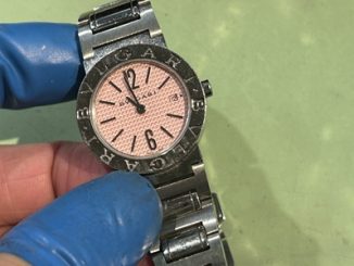 ブルガリのロゴが刻印されたベゼルを持つ、黒い文字盤の腕時計。