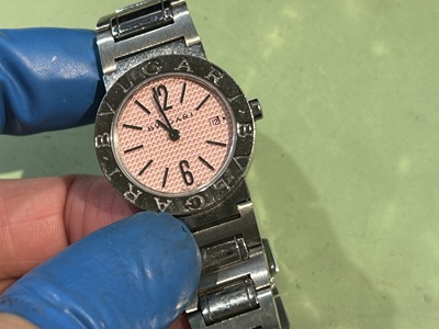 ブルガリのロゴが刻印されたベゼルを持つ、黒い文字盤の腕時計。