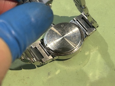 ブルガリの腕時計を裏返し、裏蓋の構造を確認している様子。