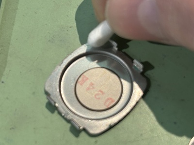 綿棒を使って裏蓋の裏側を掃除している様子。