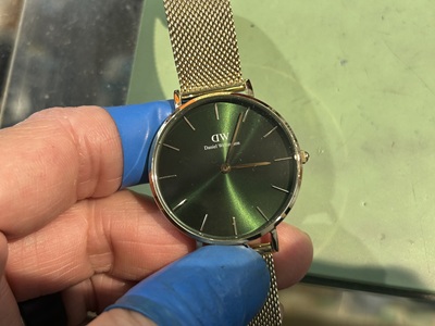 ダニエル・ウェリントンの鮮やかなグリーンの文字盤を点検する様子