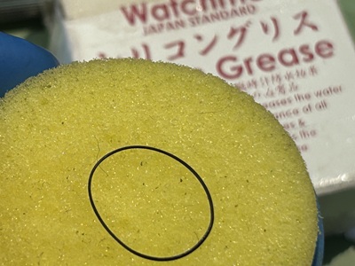 黄色のスポンジ上でパッキンにシリコングリースを塗布する様子