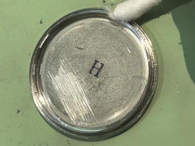 綿棒を使って裏蓋の縁を掃除する様子。