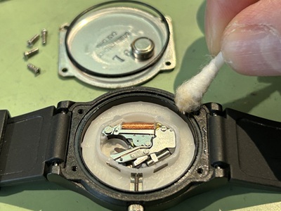 綿棒の先で、時計ケースの縁にある細い溝をなぞるように掃除している。