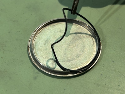 時計の裏蓋からピンセットでゴムパッキンを取り外す様子