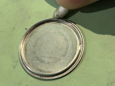 裏蓋の隙間に溜まった汚れを綿棒でクリーニングする様子