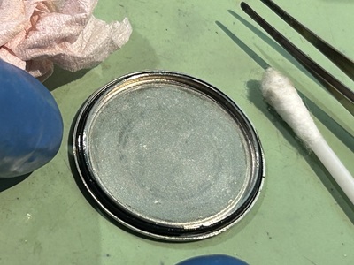 グリース処理されたパッキンを裏蓋の溝に正確に戻す様子