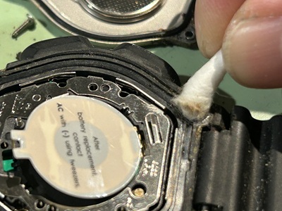 綿棒を使ってG-SHOCKのケースの溝を掃除している様子。