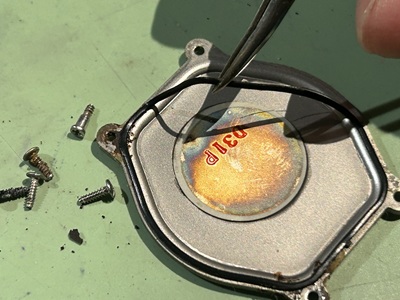 ピンセットで細いゴム製のパッキンを持ち上げている様子。