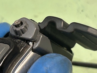 裏蓋を閉め、補助バーのネジを締めている接写写真。