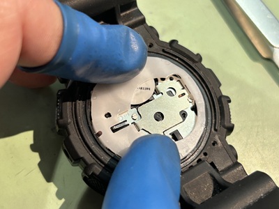 顕微鏡を覗きながら、ピンセットで端子を修正する作業風景