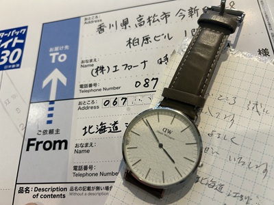 北海道から届いたレターパックと、その上に置かれたダニエル・ウェリントンの腕時計。