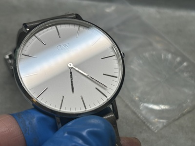 新しいガラスが装着され、光を反射して輝く時計のアップ。