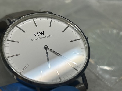 強い光の下でガラスの透明度を確認しているダニエル・ウェリントン。