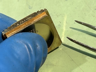 裏蓋を閉じる前に、綿棒を使ってケースの縁（隙間）を清掃している様子。