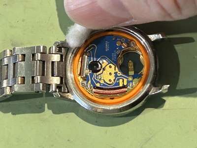 ムーブメント周囲の汚れを丁寧に拭き取っている作業風景。