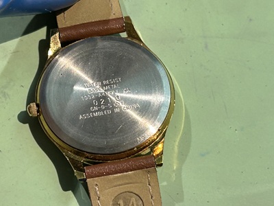 腕時計の裏蓋。構造と型番を確認している様子。