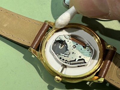 綿棒を使用してムーブメント周辺の汚れを掃き出す作業。