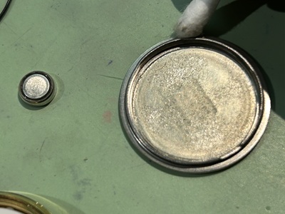 裏蓋の溝に溜まった汚れを綿棒で入念に掃除する様子。