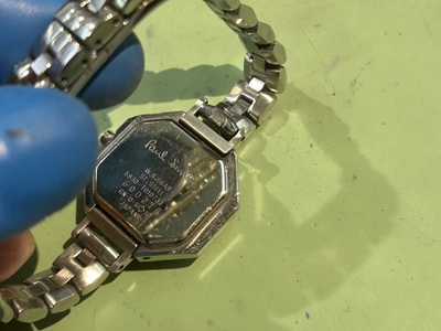 腕時計の裏蓋。ロゴと型番の刻印が見える。