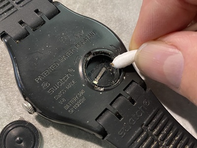 綿棒を使って電池収納部を掃除している様子。