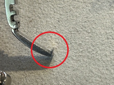 ルーペで拡大した時計の金具部分。引っかかるための突起やエッジが摩耗して丸くなっている様子
