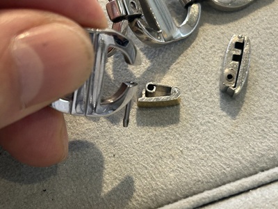 新しい代用金具の向きや位置をブレスレットに合わせて慎重に確認している手元の様子