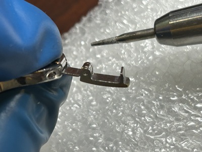 新しい代用金具が腕時計のブレスレットに見事に組み込まれ、ピンで固定された状態の写真
