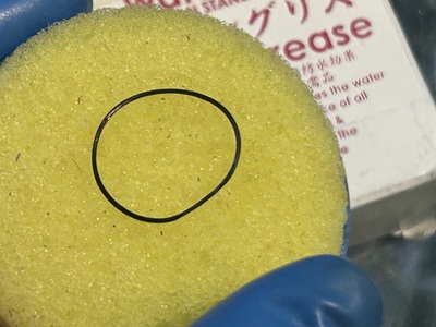 綺麗になったパッキンに専用の防水グリースを薄く均一に塗布し、メンテナンスを施しているシーン。