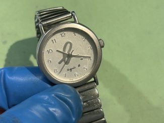 譲り受けた動かないアニエスベーの腕時計。青い手袋の指。
