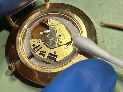 古い電池を外し、電池の接触端子やフチの汚れを綺麗に拭き取っている様子