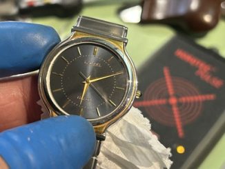 パルスチェッカーの上に置かれ、電子回路の信号計測と最終的な時刻合わせが終わったメンズ腕時計。