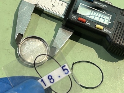 時計のサイズに合わせ、18.5mmφの新しいパッキンを選定してケースの溝に合わせている様子。