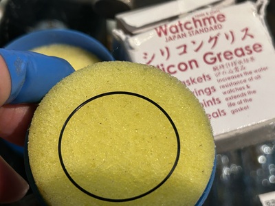 ケースから取り剥がした細いゴムパッキンに、専用の防水シリコングリースを塗布して馴染ませているメンテナンス作業。