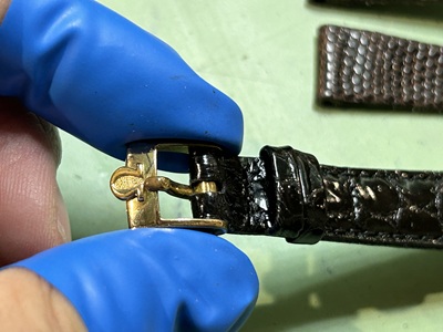 新しいクロコ革ベルトの先端に、磨き上げたオメガ純正のゴールド尾錠が美しく取り付けられた完成カット。