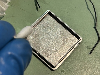 パッキンがはまる裏蓋の細い溝の汚れを綺麗に掃除している様子