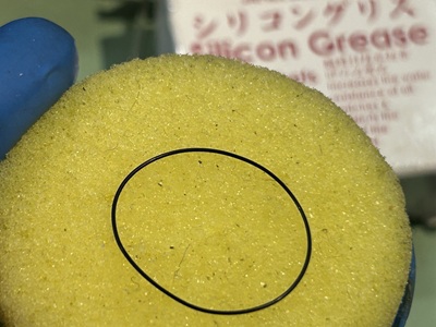 新しい輪状のゴムパッキンにシリコングリースを塗布して処理している様子