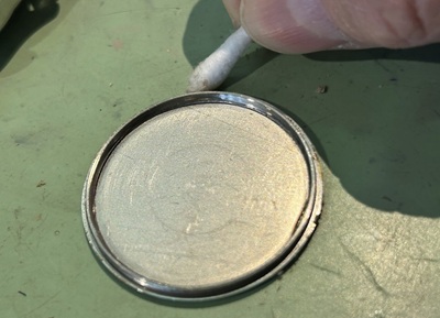 綿棒で裏蓋の隙間を掃除している様子