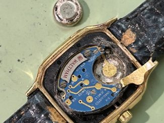 古い電池を取り外した箇所のアップ。液漏れによって白い結晶やサビが発生しているムーブメント。